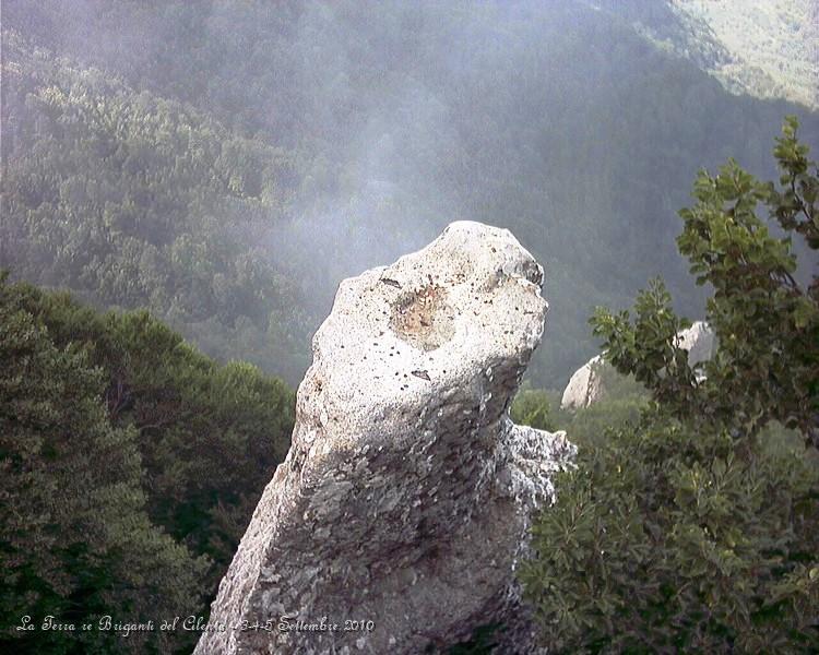 P9030438.jpg - Tutti i partecipanti si divertono a lanciare monetine sulla roccia...Questa è un pinnacolo di roccia calcarea che sporge poco oltre la balaustra del piazzale, da dove si usa lanciare monete nel tentativo di farle arrestare proprio sull'esigua superficie della bianca guglia. La leggenda narra che in età longobarda, due cavalieri giunsero sulla cima del Sacro monte Gelbison; mentre uno varcò il portale della chiesa madre per ringraziare la Madonna, l'altro lo scherniva da fuori per questo suo gesto di "debolezza" che poco si addiceva ad un vero guerriero. D'un tratto il suo cavallo s'imbizzarrì e in pochi attimi raggiunse l'orlo del precipizio per saltare oltre. Allora il cavaliere, benché non credente, implorò l'aiuto della Madonna la quale gli salvò la vita facendo arrestare la cavalcatura proprio su quello spuntone di roccia, che perciò prese la denominazione di "zampa del cavallo". Da allora sussiste l'usanza di lanciare monetine (un tempo si lanciavano sassi del suolo sacro) sulla zampa: se vi riesce un anziano, egli farà ritorno al santuario l'anno successivo. Se vi riesce una donna in cerca di marito, ella ritornerà da sposata. Alle leggende, come alle verità di fede, si può credere o no. Ma quì tutto contribuisce a rendere il pellegrinaggio un'esperienza ancora più viscerale, pura, mistica e antica. E non importa che tu sia il cavaliere credente o quello miscredente. L'importante è che cammini.