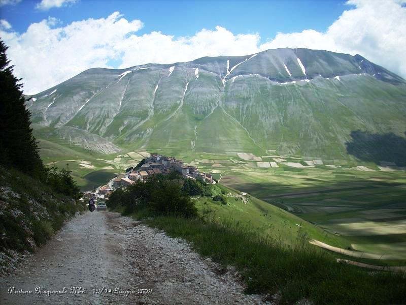 DSCN5949.JPG - Il Monte Vettore, che vediamo nella foto, è il rilievo montuoso più alto dei Sibillini, con i suoi 2.476 metri di altitudine. Durante il Pleistocene superiore (da 125.000 a 10.000 anni fa) il ghiacciaio ha trascinato in avanti detriti morenici che hanno generato uno sbarramento naturale creando un circo glaciale che oggi ospita il Lago di Pilato. La sua vetta, che si trova nel territorio della regione Marche, è la più alta di un arco montuoso che ha una caratteristica forma ad "U" e che comprende, seguendo l'arco da ovest a est, Quarto San Lorenzo, Cima Del Redentore (2448 m), Cima del Lago, il Vettore stesso, Monte Vettoretto (2032 m) e Monte Torrone (2102 m). Sulla pendice nord del monte Vettore, nella conca naturale abbracciata dall'arco montuoso, a 1.941 metri di quota si trova il Lago di Pilato. Sebbene le sue dimensioni non superino i 500 metri di diametro, il Lago di Pilato è di grande interesse tra i naturalisti e i biologi. Ospita tuttora un endemismo peculiare, una specie autoctona di gambero: il Chirocefalo del Marchesoni. Questo gamberetto, dal colore rossastro, raggiunge una lunghezza di 9-12 mm e si muove nuotando all'indietro con il ventre rivolto verso l'alto. Fu scoperto dal Prof. Marchesoni durante il corso di studi e ricerche. La facciata esterna dell'arco montuoso invece domina il Pian Grande di Castelluccio di Norcia, una vallata ricca di coltivazioni di lenticchia, legume caratteristico del luogo. Dalla vetta del monte si può ammirare in giornate limpide il Gran Sasso a sud-est e il Terminillo a sud-ovest, il litorale marchigiano e l'Adriatico ad est.